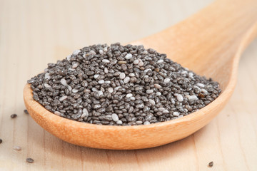 Nutritious chia seeds in  wooden spoon on wood table