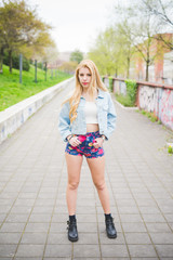 Fototapeta na wymiar Young handsome blonde caucasian fashion girl posing on a park in