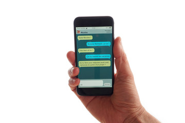 Une main tient un smartphone avec une discussion par SMS