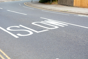 Slow down sign painted on road