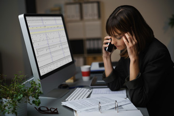 frau arbeitet im büro bis spät am abend und telefoniert