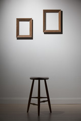 empty frames and chair on a white wall, interior