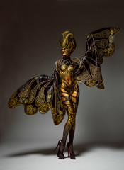 Studio portrait of beautiful model with fantasy golden butterfly body art and crown