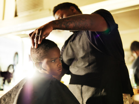 little boy getting his hair cut in barber shop