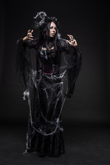 Portrait of beautiful Gothic woman in dark dress in studio