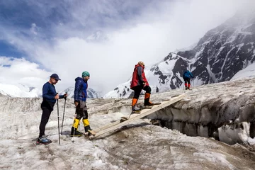 Papier Peint photo Lavable Alpinisme Personnes traversant la crevasse du glacier sur une passerelle tremblante en bois Groupe d& 39 alpinistes avec des bottes et des vêtements de haute altitude traversant la section de glace lors de l& 39 ascension d& 39 une expédition alpine dans la région 