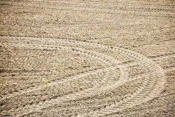 Fototapeta na wymiar Tractor footprints on plowed field - full frame image