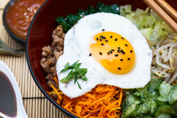 Korean cuisine, beef  Bibimbap in  a clay pot on wooden table