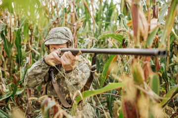 hunter in camouflage clothes ready to hunt with hunting rifle