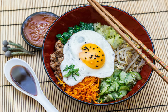 bibimbap in a bowl on bamboo mat, korean dish