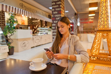 beautiful girl using smartphone in cafe