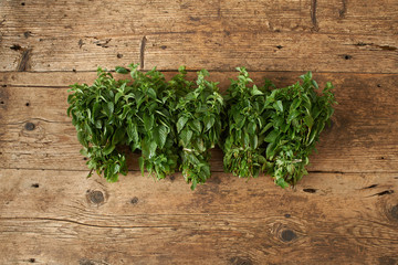 bunch of fresh spearmint on wooden bench