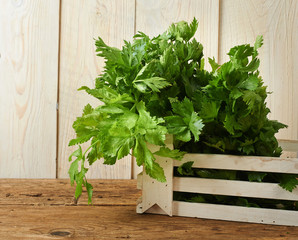 bunches of fresh celery on wooden bench