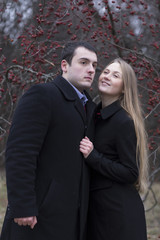 young couple standing in falling park