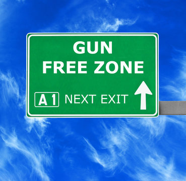 GUN FREE ZONE road sign against clear blue sky