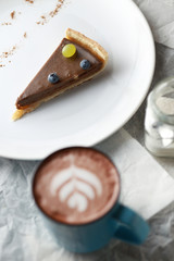 Cup of cacao and a piece of cake. Latte art.