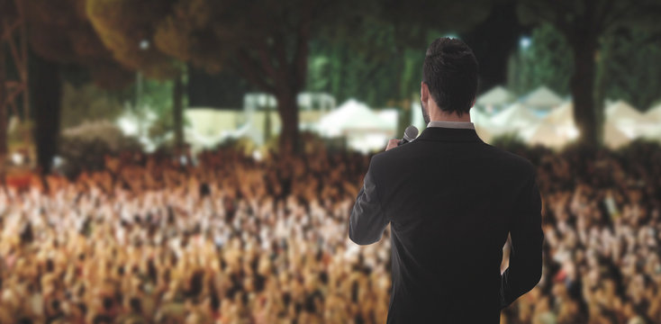 Uomo parla su palco folla 