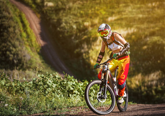 Extreme sports - young woman riding downhill bike