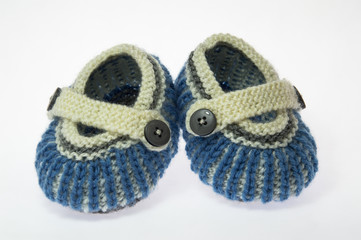 Handmade knitted woolen baby booties on white background