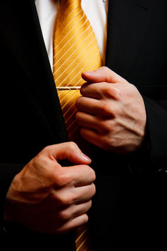 Man's suit with yellow tie and hands closeup