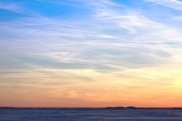 Naklejka na ściany i meble Sunset over the snowy desert. Bright orange blue sky