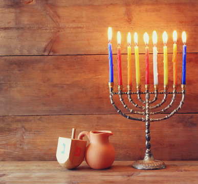 low key image of jewish holiday Hanukkah with menorah (traditional Candelabra) and wooden dreidels (spinning top)
