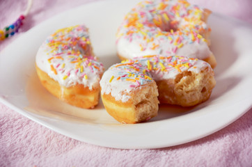half-eaten donuts on the plate close-up pink color