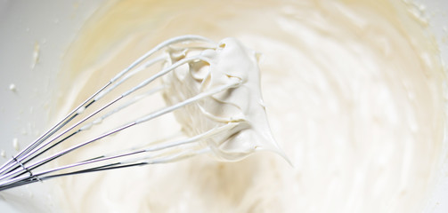 Whipping cream with a whisk close up