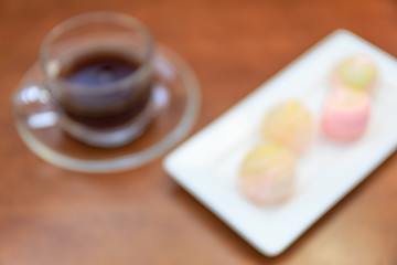 Blur Chinese pastry and black coffee on wood plane