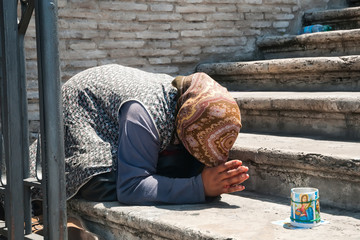 Beggar in Rome - female street beggar in prayer pose