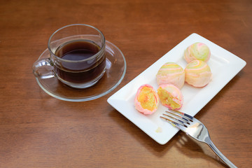 Chinese pastry and black coffee on wood plane