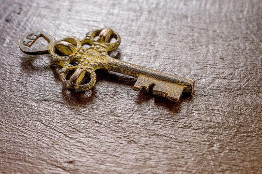 Old treasure key on wood surface