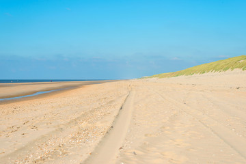 Fototapeta na wymiar Tire tracks on a beach ending in sea