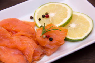 Smoked salmon inside tray on wooden table seen from very close
