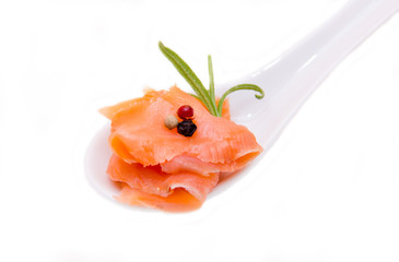 Smoked salmon on spoon on white background seen close