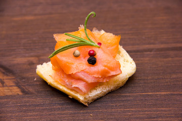 Smoked salmon on toasted bread on wooden table