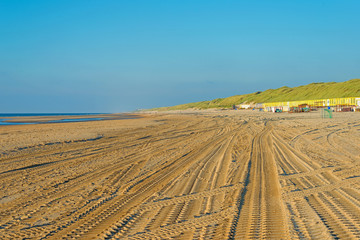 Tire tracks on a beach ending in sea