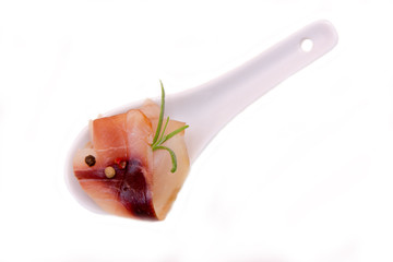 Smoked swordfish on teaspoon on white background seen from above