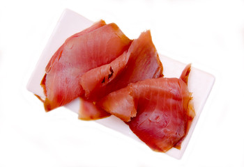 Smoked tuna on small tray on a white background seen from above