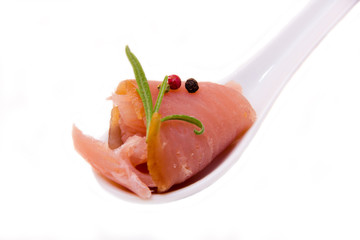 Teaspoon of smoked tuna on a white background seen close