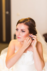 Fototapeta premium Beautiful young bride with wedding makeup and hairstyle