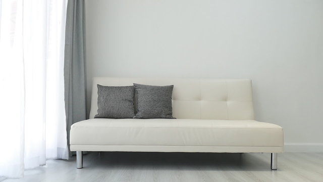 White sofa in the room with moving curtain by the wind 