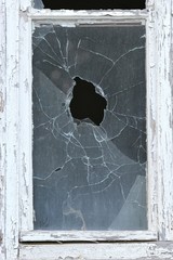 eingeworfenes Fenster eines verlassenen Wohnblocks