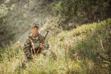 hunter in camouflage clothes ready to hunt with hunting rifle