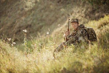 hunter in camouflage clothes ready to hunt with hunting rifle