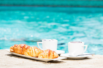 Two cups of coffee with latte art and croissants