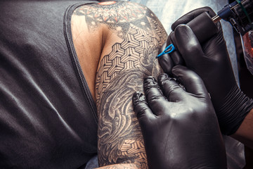 Professional tattooer working tattooing in tattoo studio