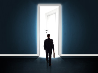 Fototapeta premium Business man looking at big bright opened door