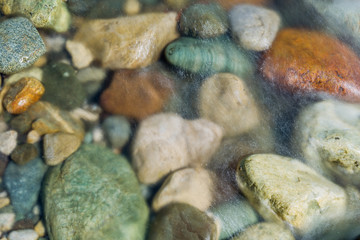 Pebble stones in the river water close up view blurred motion