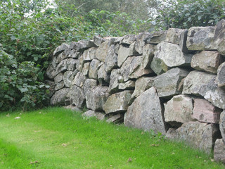 Traditional drystone wall fence as house boundary in Falkenberg, Sweden.